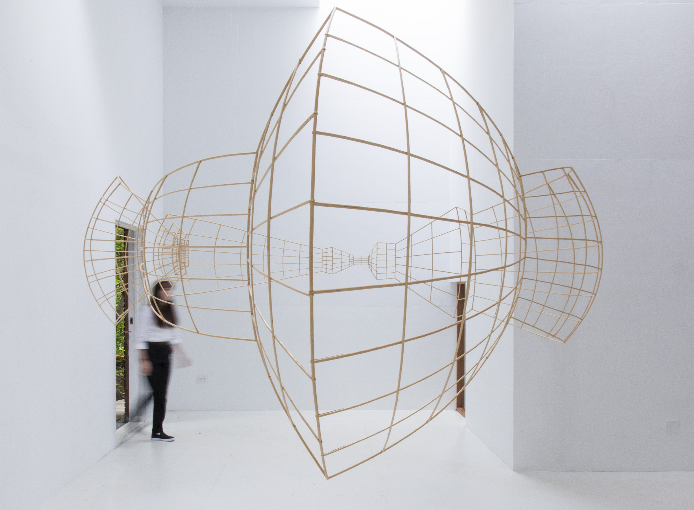 Ricci Albenda’s Open Universe fluctuates between the fields of sculpture and architecture. Through the use of vanishing points sculpted with bent willow, Open Universe is illusion in space.
